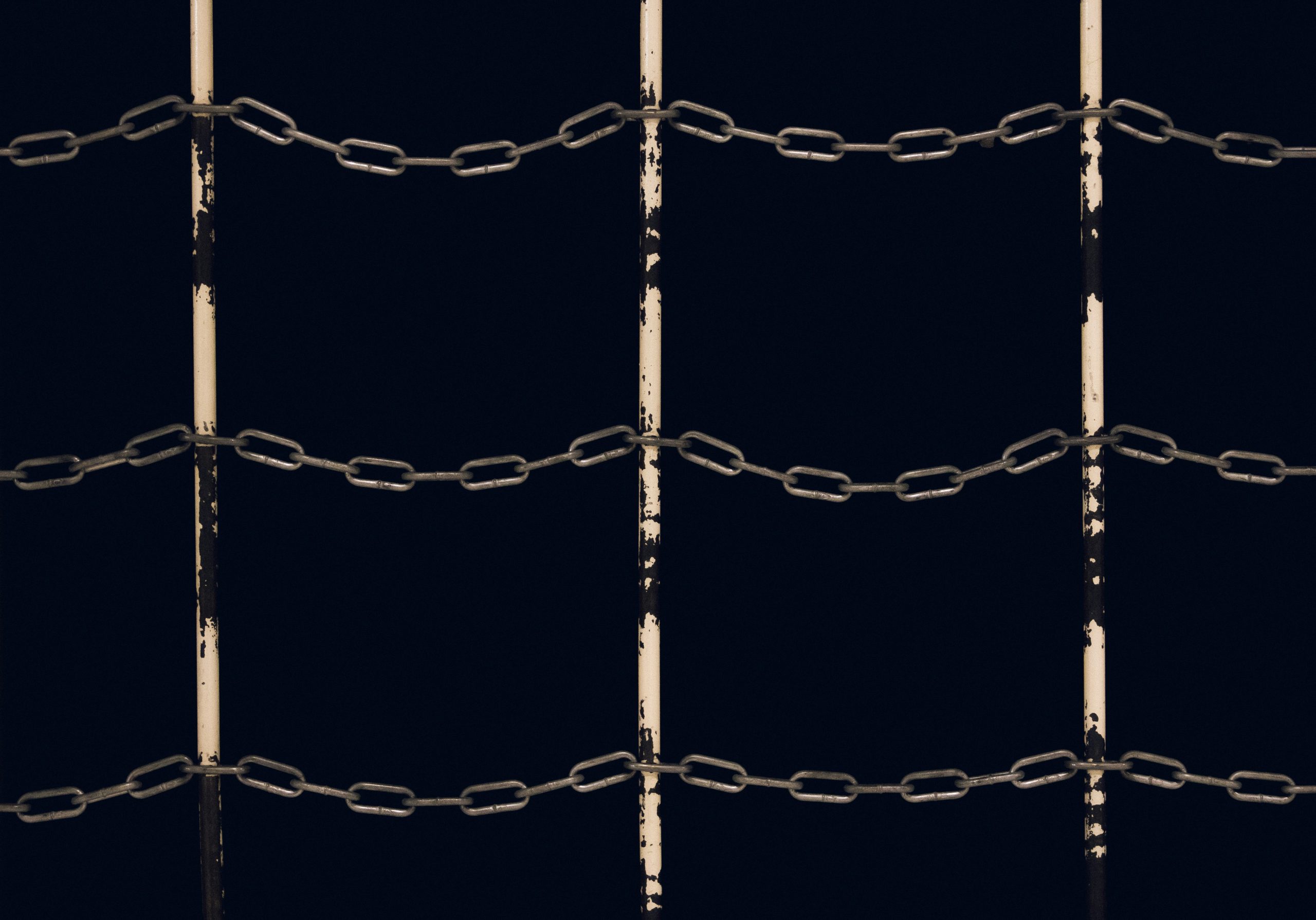 Photograph of chains linked together over a black background