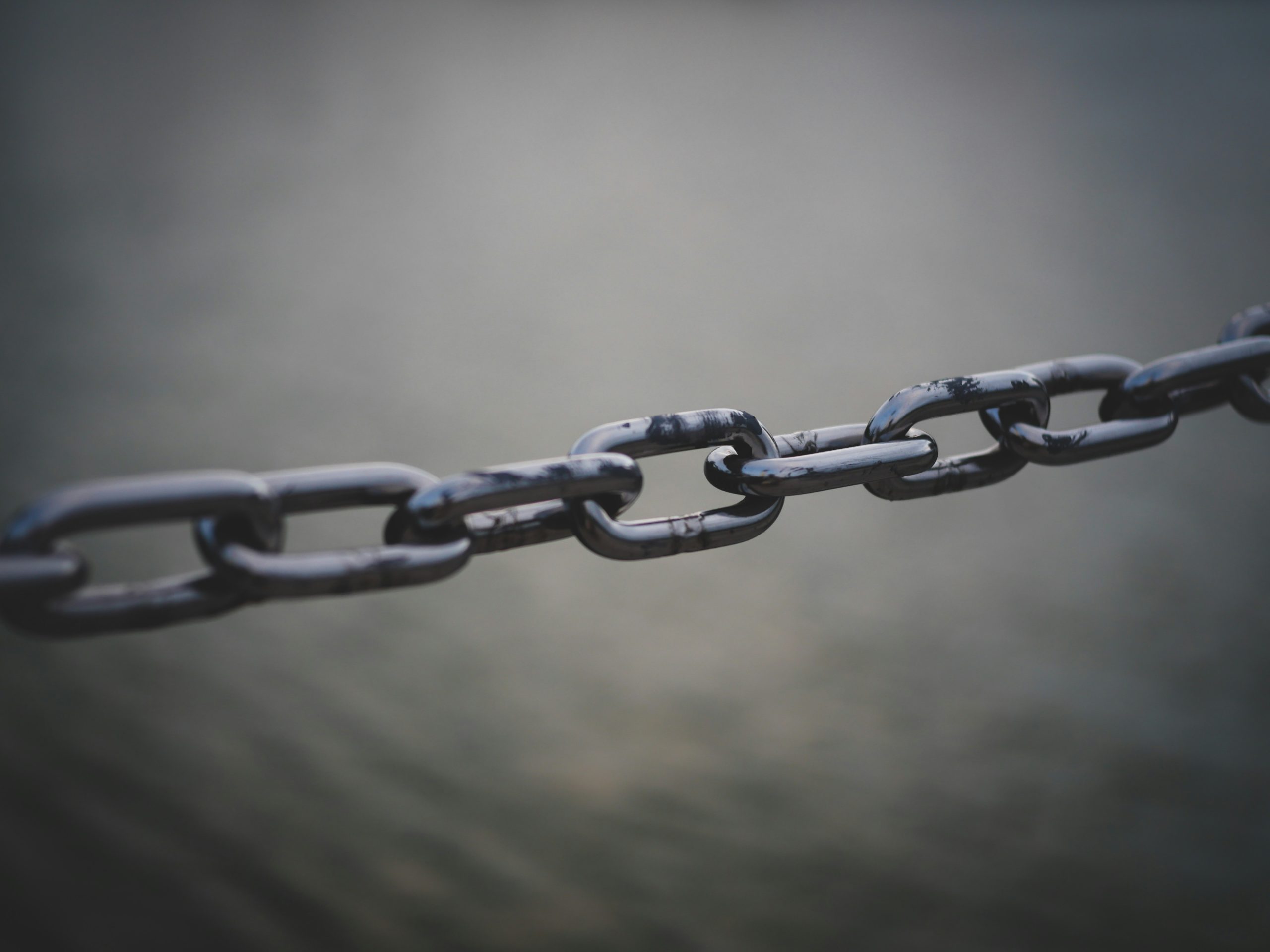 Photograph of a piece of horizontal chain over a grey background