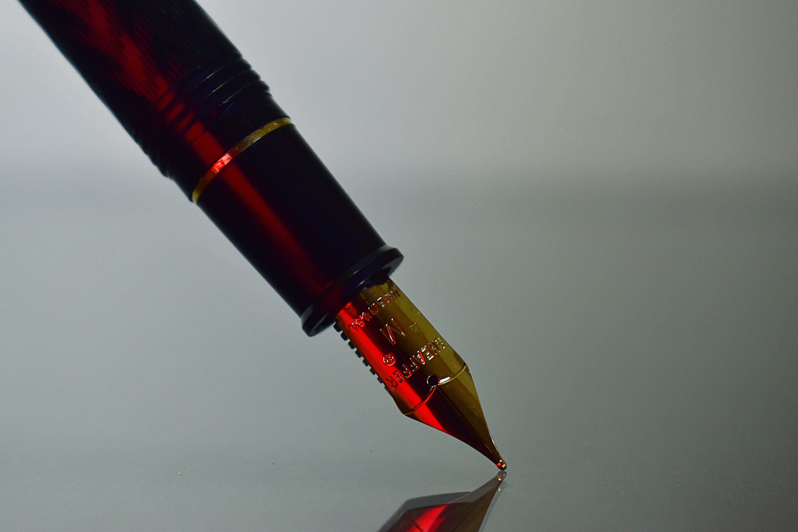 Photograph of a close up fountain pen highlighted by red light