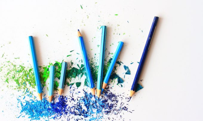 Blue colored pencils with shavings around them